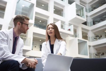Doctors discussing a mutual patient in hospital